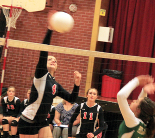 Shayla VonBargen spikes the ball against Potlatch. #11 is Krystin Uhlenkott.