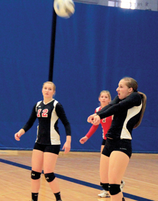 Hailey Danly makes a pass. Also shown are Kayla Schumacher and Chaye Uptmor.