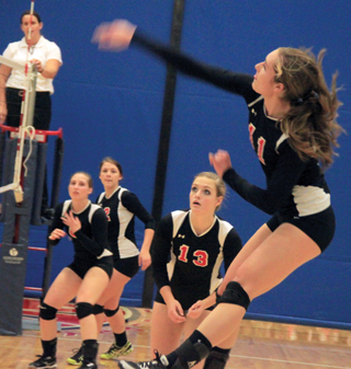 Krystin Uhlenkott pounds the ball over against C.V. at District. Also shown are Hailey Danly, Natasha Gimmeson and Holli Uhlorn.