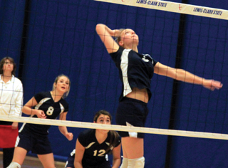 Ally Sonnen winds up for a spike as Lauren Stubbers and Megan Seubert watch.