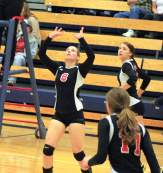 Hailey Danly sets the ball as Tasha Gimmeson and Krystin Uhlenkott each get ready for the kill.