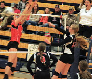 Kayla Schumacher pounds the ball past Troys blocker as Hailey Danly is ready in case the ball would have been blocked. In the foreground is Krystin Uhlenkott.