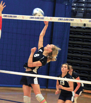 Lauren Stubbers goes for a spike against Deary as Rachel Waters watches after making a set. Behind Waters is Lucy Osborne.