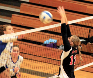 Holli Uhlorn blocks a Genesee spike in the championship match, one of 15 blocks she had in the tournament.