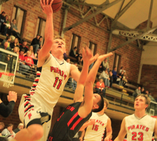 Jake Bruner drives in for a layup at Moscow. Also shown are Tanner Ross and Lucas Arnzen.