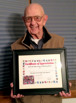 Mark Tacke is shown with a Certificate of Appreciation from the people of Mthatha, South Africa to the Cottonwood community.