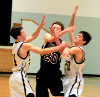Josh Lustig appears to get all tangled up with a pair of Logos defenders after making a pass.