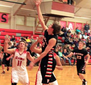 Bryson Higgins scores on a layup against C.V. Lucas Arnzen is at right. Terran Peery is partially hidden at left.