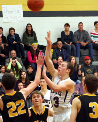 Thomas Schwartz lofts a shot from the lane as the Summit crowd looks on in the background. Also shown is Tyler Krogh.