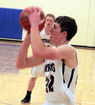 Patrick Chmelik shoots from the baseline against Salmon River. Also shown is Nathan Beckman.