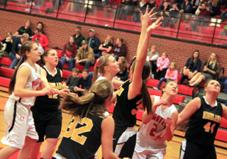 From left, Shayla VonBargen and Prairies 2 seniors, Kayla Schumacher and Tasha Gimmeson look up to see whether Schumachers shot went in against Highland on Senior Night.
