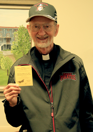 Fr Meinrad proudly shows off his Mardi Gras ticket; he was first one to purchase a ticket to the St. Marys Hospital 2015 Mardi Gras event.