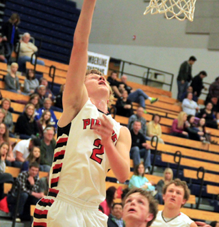Rhett Schlader scores a layup against Troy. At right is Calvin Hinkelman.