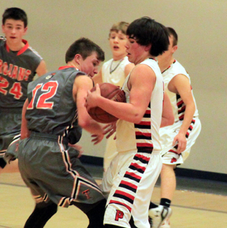 Terran Peery takes the ball away from a Troy player. Also shown are Brandon Higgins and Devin Bruegeman.