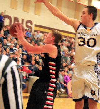 Jake Bruner goes for a reverse lay-up to avoid the block of Ambrose's Travis Yenor.