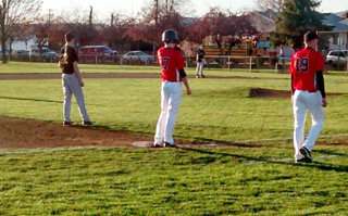 John Mager stands on third after his triple against Highland. At right is coach Kyle Westhoff. Photo by John Mager, Sr.