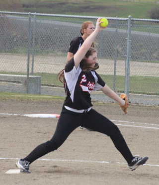 Faith Uhlenkott pitches against Troy. In the back is Sarah Seubert.