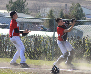Catcher Brandon Anderson catches a popup against Kamiah. At left is pitcher Devin Bruegeman.
