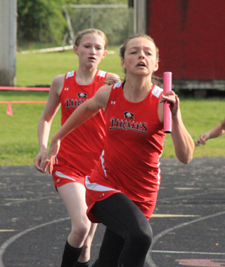 Delaney Uhlenkott has handed off to Nicole Poxleitner in the 4x100 relay.