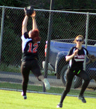 Kellie Heitman makes a leaping catch after a long run in the game against Genesee. Also shown is Abbie Uhlenkott.