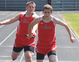 Ryan Glimp hands off to Anthony Karel in the 4x200 relay.