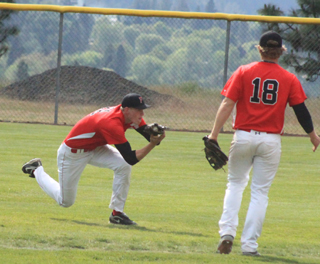 Jake Bruner came in a long way for a catch in the second Potlatch game at District. Also shown is shortstop Calvin Hinkelman.