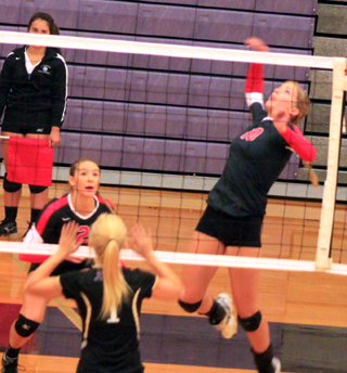 Chaye Uptmor goes up for a spike against Kellogg at the Lewiston Tournament. Also shown is Mykaela McWilliams.