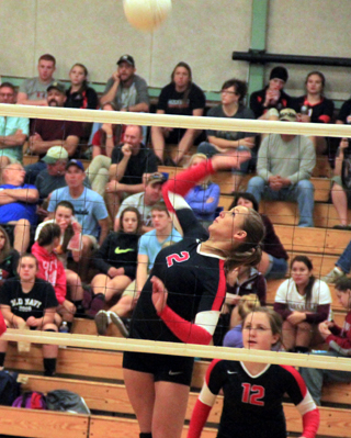 Mykaela McWilliams spikes the ball against St. John-Endicott. Also shown is Angela Wemhoff.
