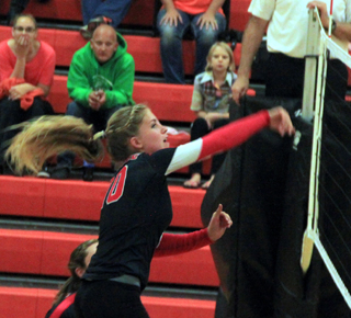 Chaye Uptmor spikes the ball at Troy.