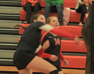 Shayla VonBargen powerslams the ball at Troy. Also shown is Sarah Seubert.