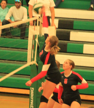 Mykaela McWilliams spikes the ball against Potlatch. Also shown is Hailey Danly.