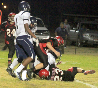 Bobby Hood, center of the photo, and Calvin Hinkelman met at the quarterback for one of Prairies 7 sacks. At left is Daniel Mager.