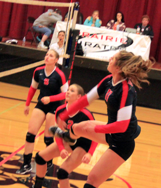 Krystin Uhlenkott follows through after smashing the ball over the net. Also shown are Hailey Danly and Mykaela McWilliams.