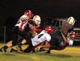 Isaiah Shears, 4, and Brandon Anderson, right, sack Troys quarterback for a loss. Were not sure who the player at left is.