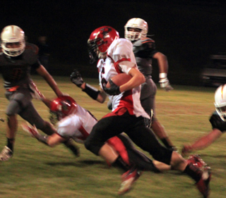 Luke Wemhoff runs with the ball as a teammate lays out trying to make a block.