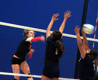 Krystin Uhlenkott pounds a spike between two Lapwai blockers at District.