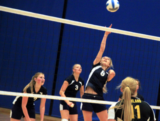 Lauren Stubbers goes for a spike against Highland at District. Also shown are Lucy Osborne and Ally Sonnen.
