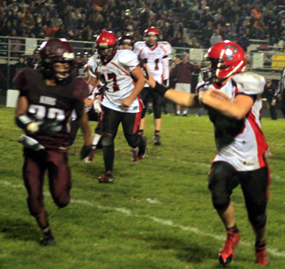 Calvin Hinkelman gains yardage on a run around left end. Also shown are Hunter Hasselstrom, 77, and Jake Bruner.