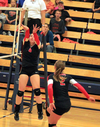 Hailey Danly looks like shes just shot a basketball as she makes a set the length of the net to Krystin Uhlenkoot. Also shown is Mykaela McWilliams.