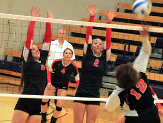 Hailey Danly and Mykaela McWilliams go up for a block as Shayla VonBargen gets ready for a dig.