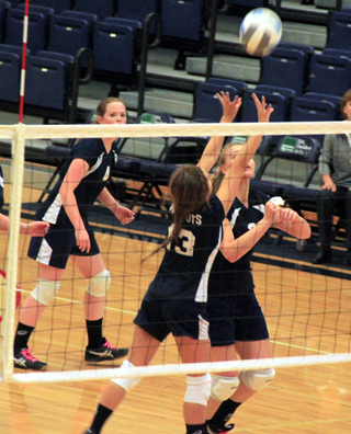 Rachel Waters sets the ball as Ally Sonnen gets ready to go up for the kill. At left is Bridget Beckman.