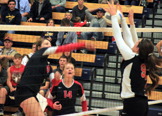 Shayla VonBargen slams the ball into the Troy blocker. She got a point on this play as the ball dropped down between the Troy player and the net. Watching is Sarah Seubert.