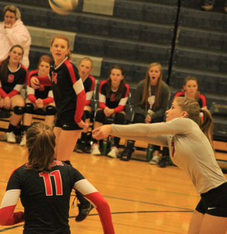 Chaye Uptmor makes a pass in the championship match. Also shown are Krystin Uhlenkott and Sarah Seubert and the Prairie bench.