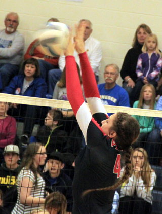 Shayla VonBargen had a huge tournament at the net both spiking and blocking and is shown here blocking a Genesee spike attempt.