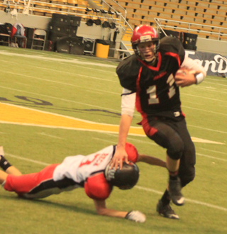 Jake Bruner stiffarms an Oakley defender to the turf as he carries the ball to the left side.