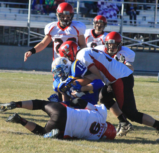 Terran Peery, on the ground, and Philip Spencer combine on a tackle. Also shown are Calvin Hinkelman, Luke Wemhoff and, we think, Brandon Anderson.