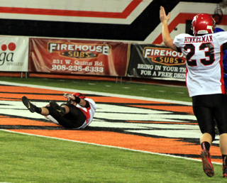 Calvin Hinkelman signals touchdown as Terran Peery falls backwards into the end zone after catching a 31 yard pass.