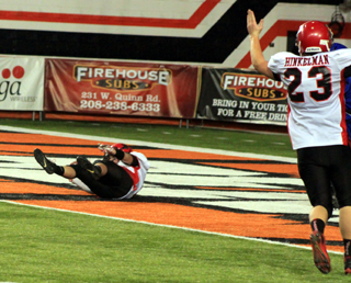 Calvin Hinkelman signals touchdown as Terran Peery falls backwards into the end zone after catching a 31 yard pass.