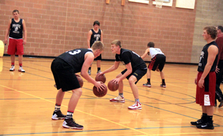 Prairie varsity players take part in a ballhandling drill as they dribble two basketballs each. Dribbling from left are Spencer Schumacher, Jake Bruner and Thomas Schwartz. Ryan Glimp, Terran Peery and Calvin Hinkelman wait their turn with the balls. Coach Teel Bruner can be seen behind Hinkelman.