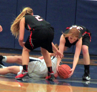 Josie Peery grabs a loose ball in the Grangeville game last week. Also shown is Kylie Tidwell.